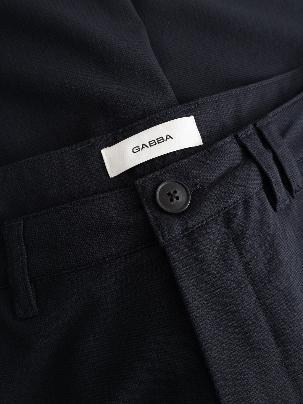 Close-up of GABjet Deme Shorts in dark navy by Gabba, featuring a slim-fit design, black button closure, and a white Gabba label above the waistband.