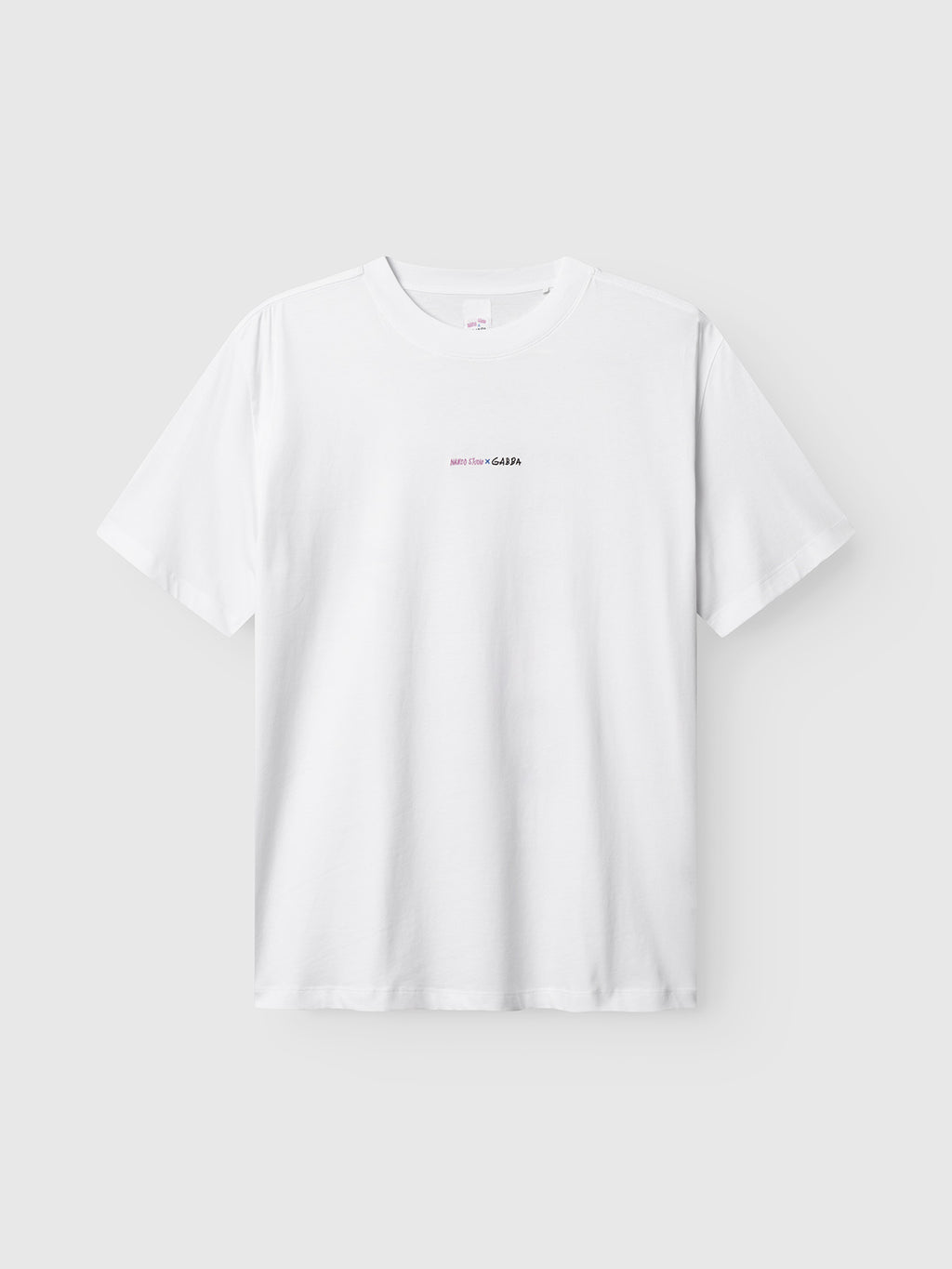 The Gabba GABnigel Boxy Nando SS T-Shirt GOTS in white features small black and pink minimal text centered on the chest. It is a short-sleeve tee displayed against a light gray background.
