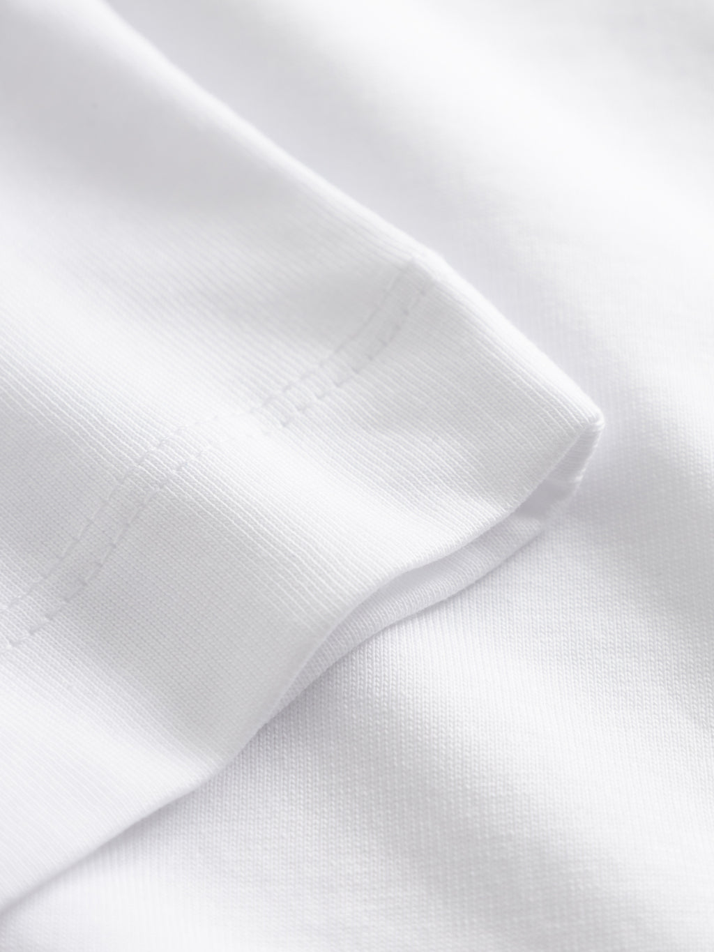 Close-up of the Gabba GABnigel Boxy Nando SS T-Shirt GOTS in white, featuring the sleeve edge with visible stitching and smooth, soft cotton fabric.