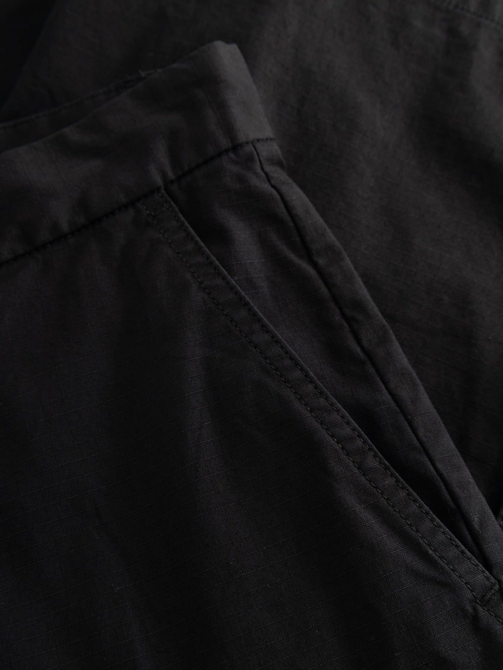 Close-up of Gabba GABjoli Cargo Ripstop Shorts in black, showcasing side cargo pockets and visible stitching on smooth, slightly textured fabric—ideal for a versatile everyday look.