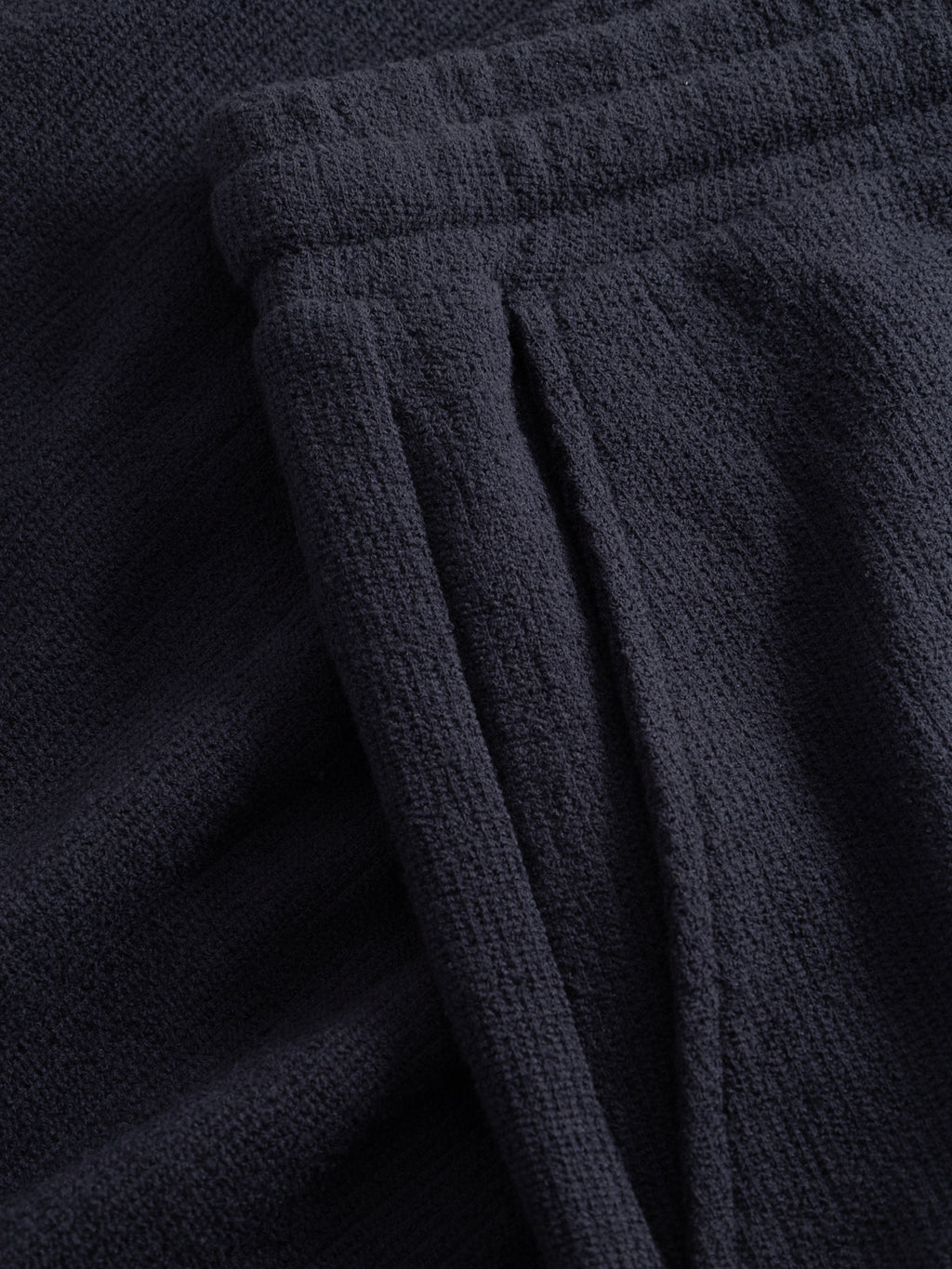 Close-up of Gabba's GABtommi Towel Shorts in navy, highlighting the elastic waistband and side pocket. Made from soft terry cotton, these shorts offer comfort and warmth with a cozy, slightly fuzzy texture.