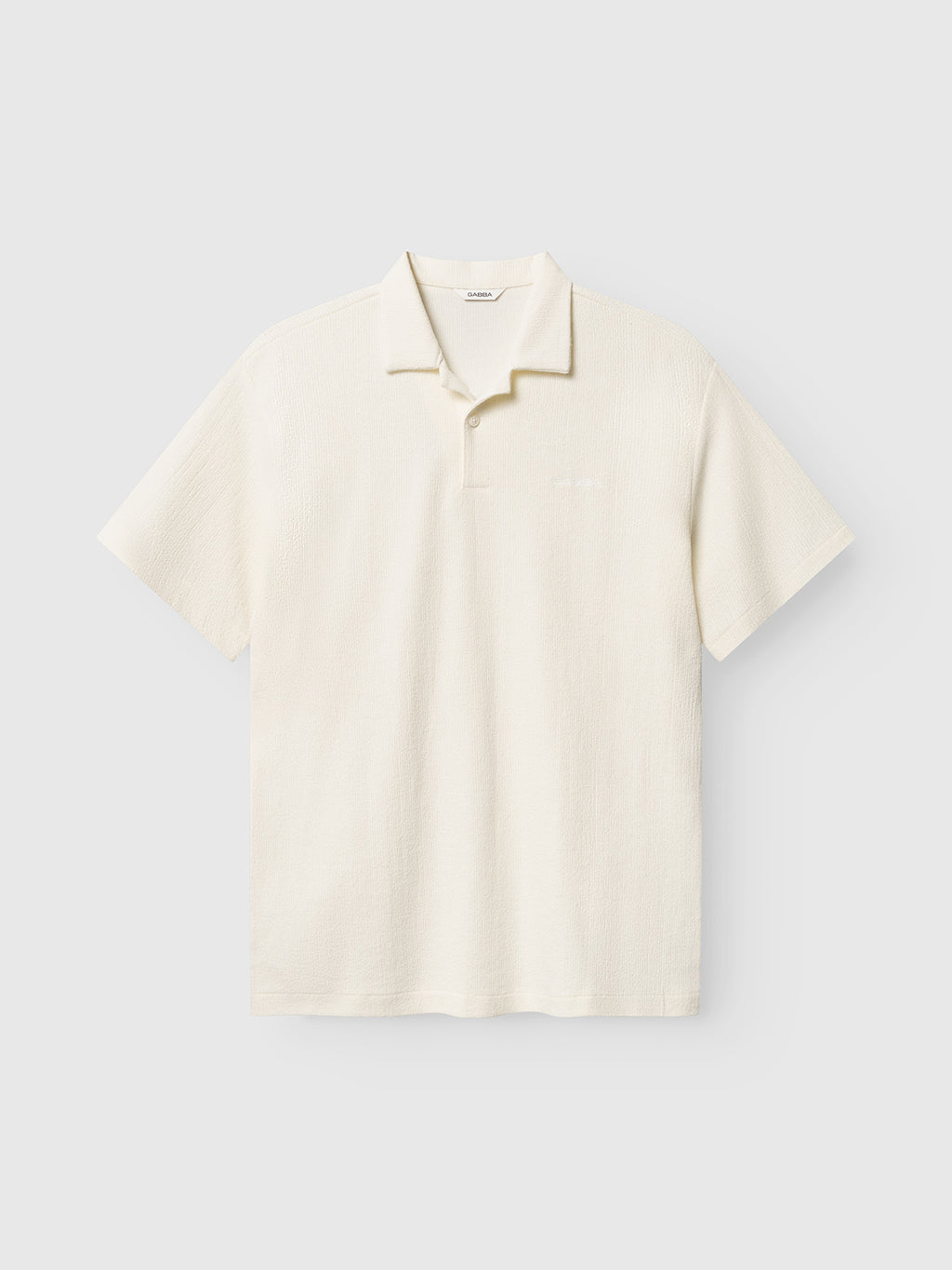 The Gabba GABlio Sku Towel T-Shirt in Egret is a short-sleeve terry cotton polo with a classic collar and button placket, shown on a plain light background.
