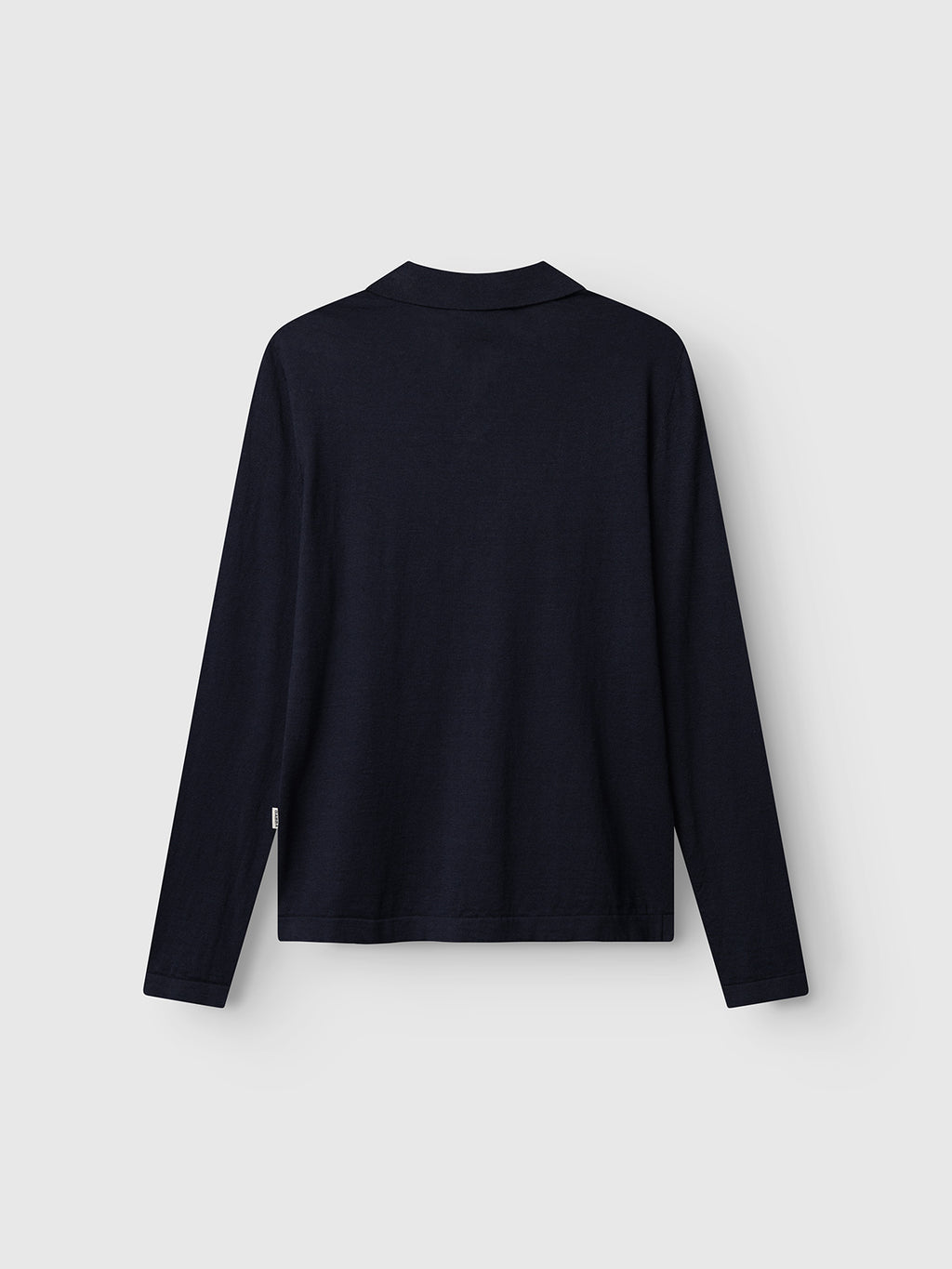 The image shows the Gabba GABcross Dush LS Knit - Navy, a plain long-sleeve knit shirt with a simple collar and modern silhouette, pictured from the back and laid flat on a light gray background. No visible patterns or logos are present.