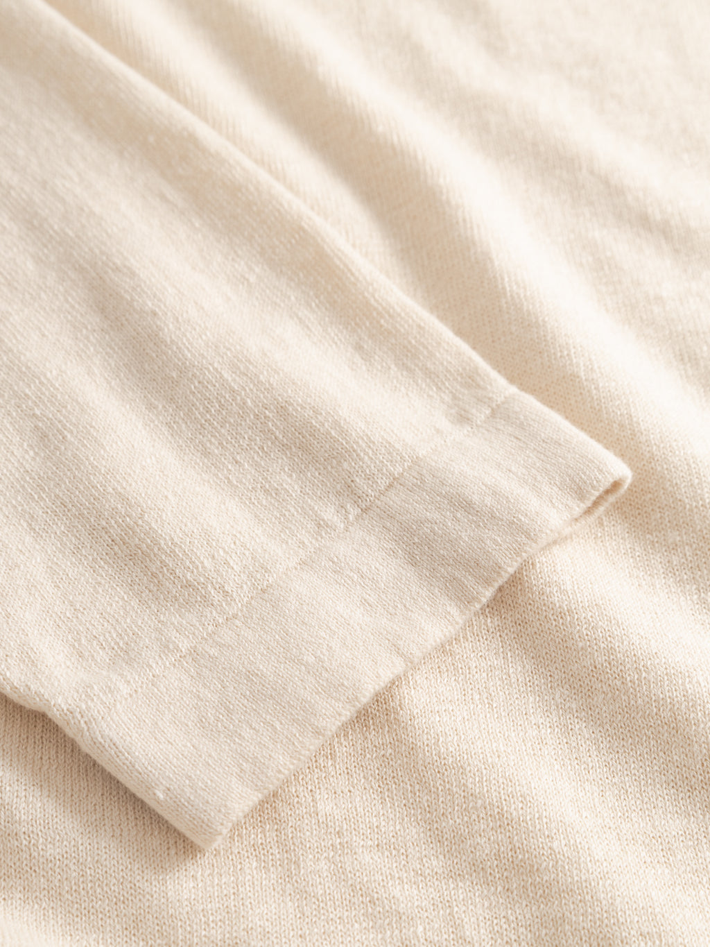 Close-up of the Gabba GABcross Dush LS Knit in Sand Mel, showcasing its soft, slightly heathered fabric and fine cuff stitching. The flat knit texture highlights the garment’s refined details and cozy appeal.