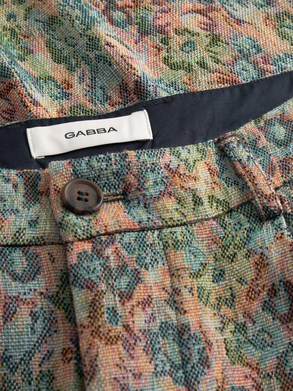 Close-up of GABjoli Ted Kscope Shorts by Gabba featuring abstract flower patterns, textured fabric, button fastening, and a white Gabba label for versatile seasonal style.