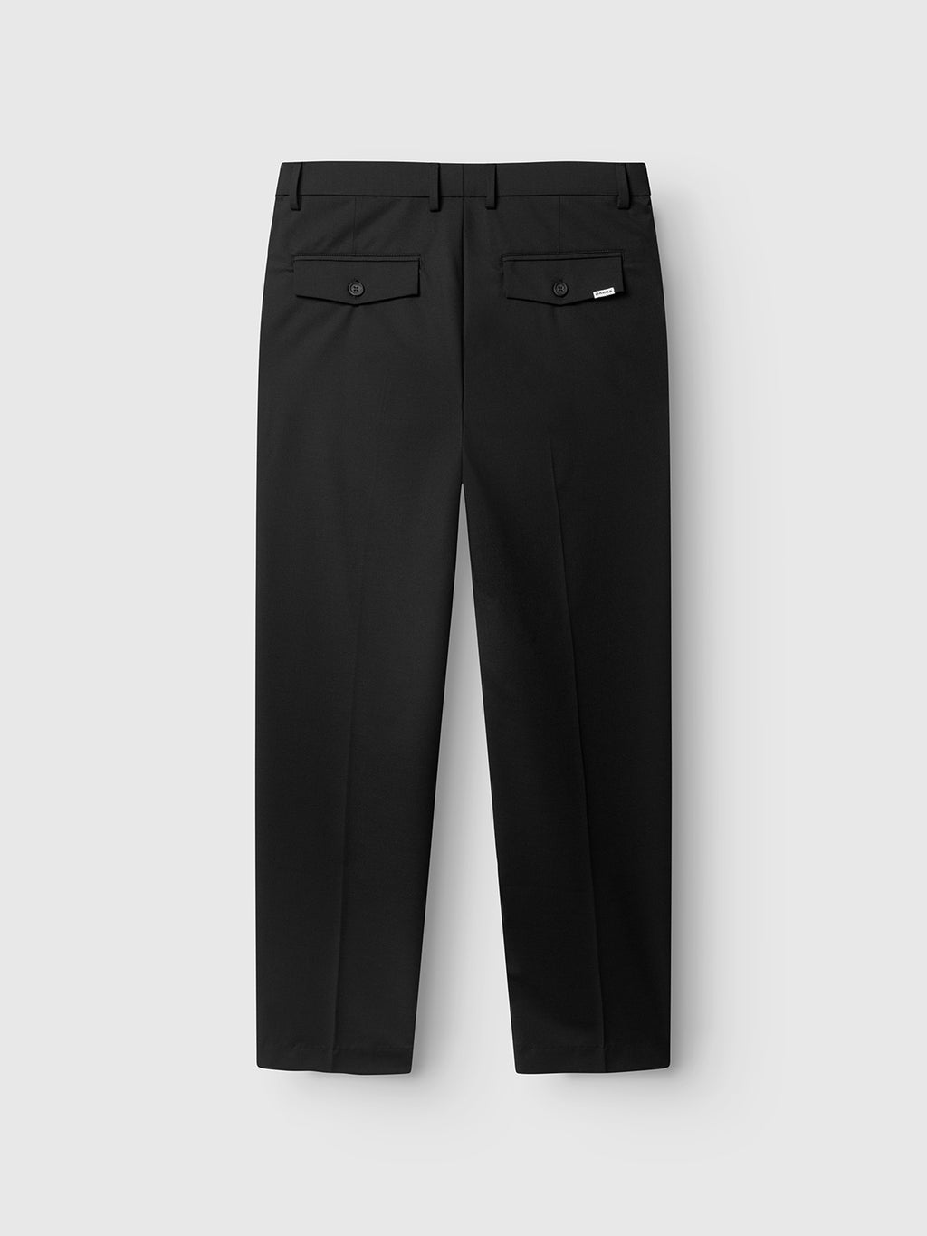 The GABjoe Tailor Dressy Pant - Black by Gabba is shown flat on a light gray background, displaying the back view with two buttoned flap pockets and a small white tag above the right pocket.