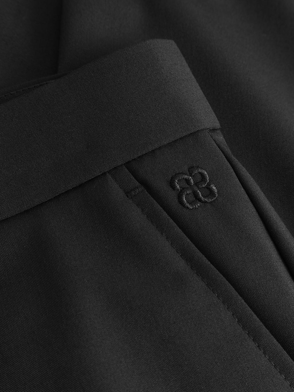 Close-up of Gabba GABjoe Tailor Dressy Pant in black, showing the waistband, pocket, and a subtle matching black embroidered logo above the pocket.