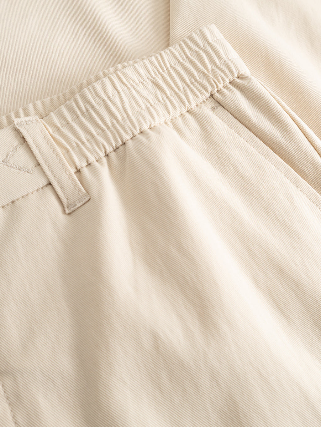 Close-up of the Gabba GABmonza Tasca Bolu TENCEL™ Pant in Birch, showing an elastic waistband, belt loop, and side pocket. The soft, lightweight fabric provides a relaxed straight fit with a fine texture.