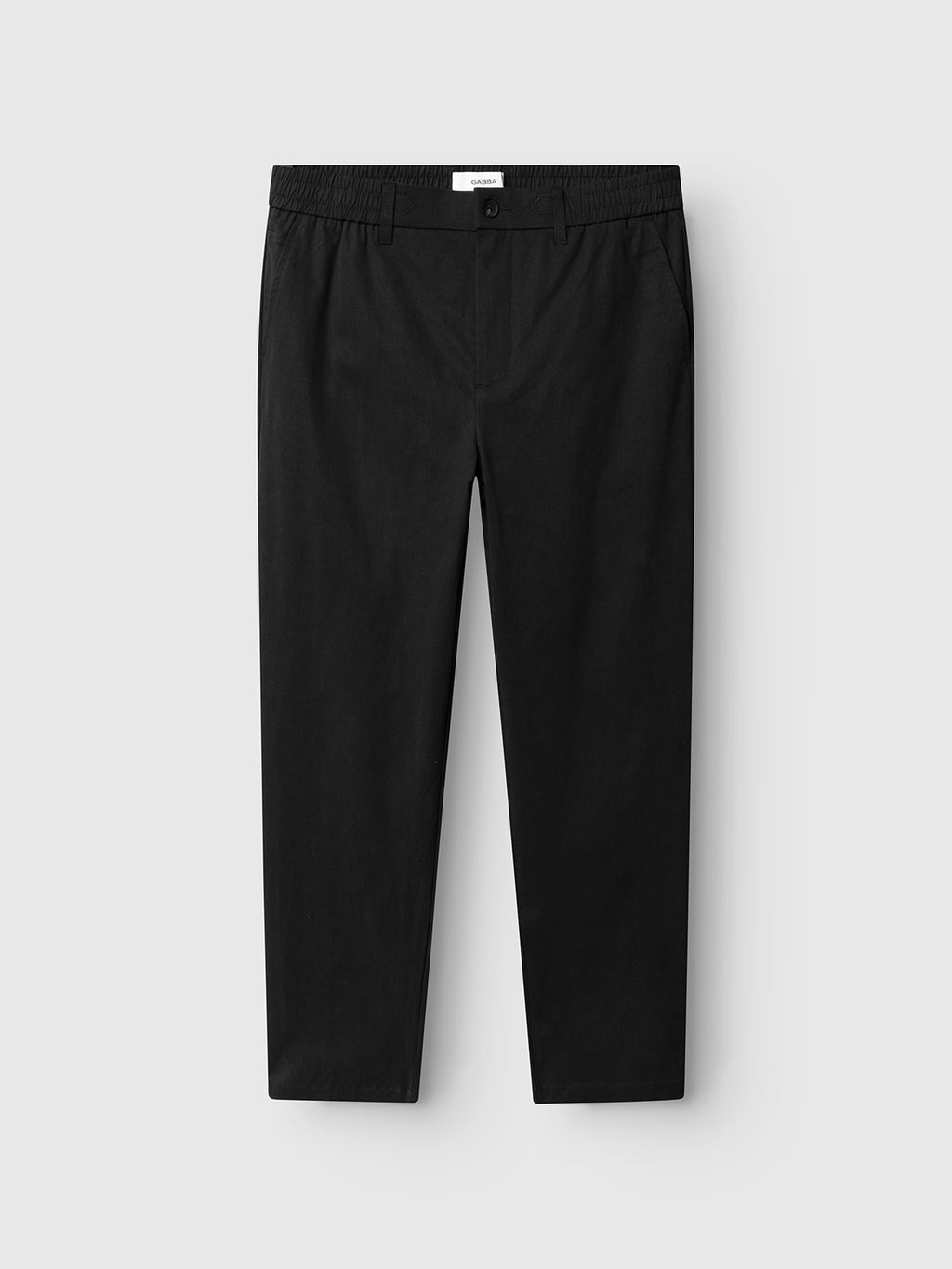 The Gabba GABmonza Tasca Bolu TENCEL™ Pant in black features a relaxed straight fit, button closure, side pockets, and an elastic back waistband, shown laid flat on a light gray background.