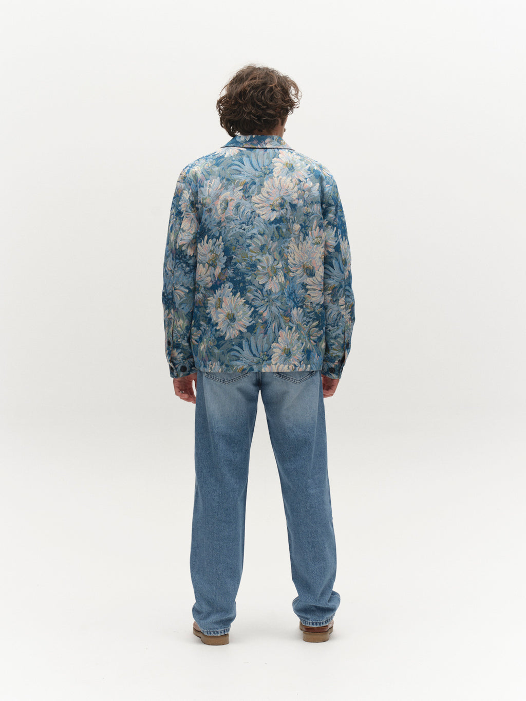 A person with curly hair, seen from behind, wears the Gabba GABsimone Art LS - Blue Pattern overshirt and light blue jeans, standing against a plain white background.
