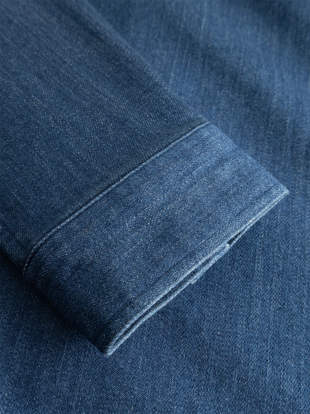 A close-up of the cuff of the Gabba GABbeta Denim LS Overshirt in Mid Blue Denim, highlighting its stretch cotton texture and signature workwear stitching details.