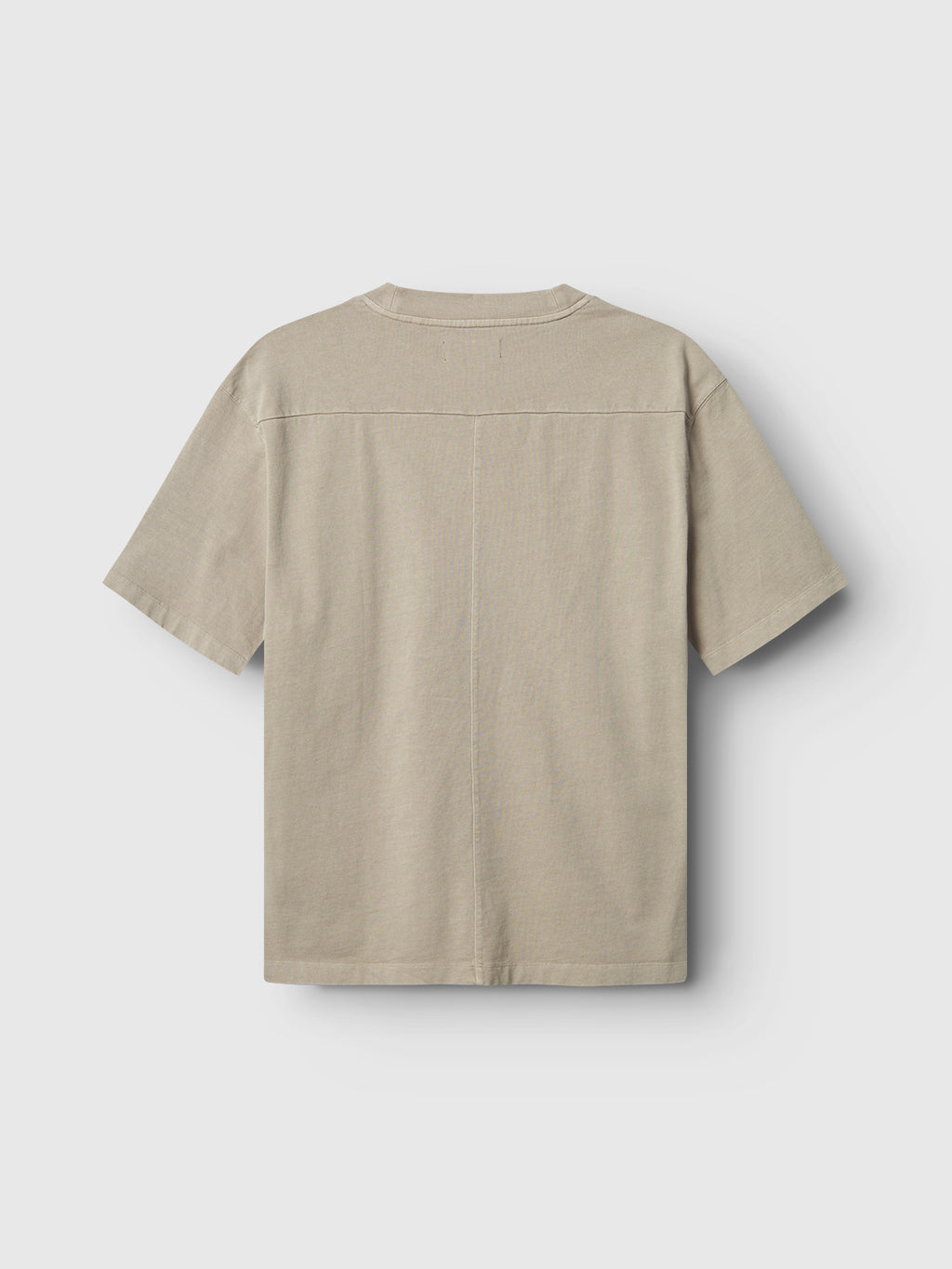 The Gabba GABnigel Wix Boxy Hour SS in Sand Cashmere is pictured from the back, highlighting its heavyweight cotton, straight center seam, and shoulder detailing against a plain light gray backdrop.