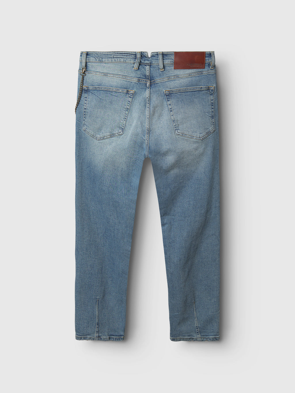 The Gabba GABalex Cros Cropped - Lt. Blue Denim features a relaxed fit, two back pockets, a brown leather patch on the waistband, and visible stitching details. The light blue jeans are shown from the back.