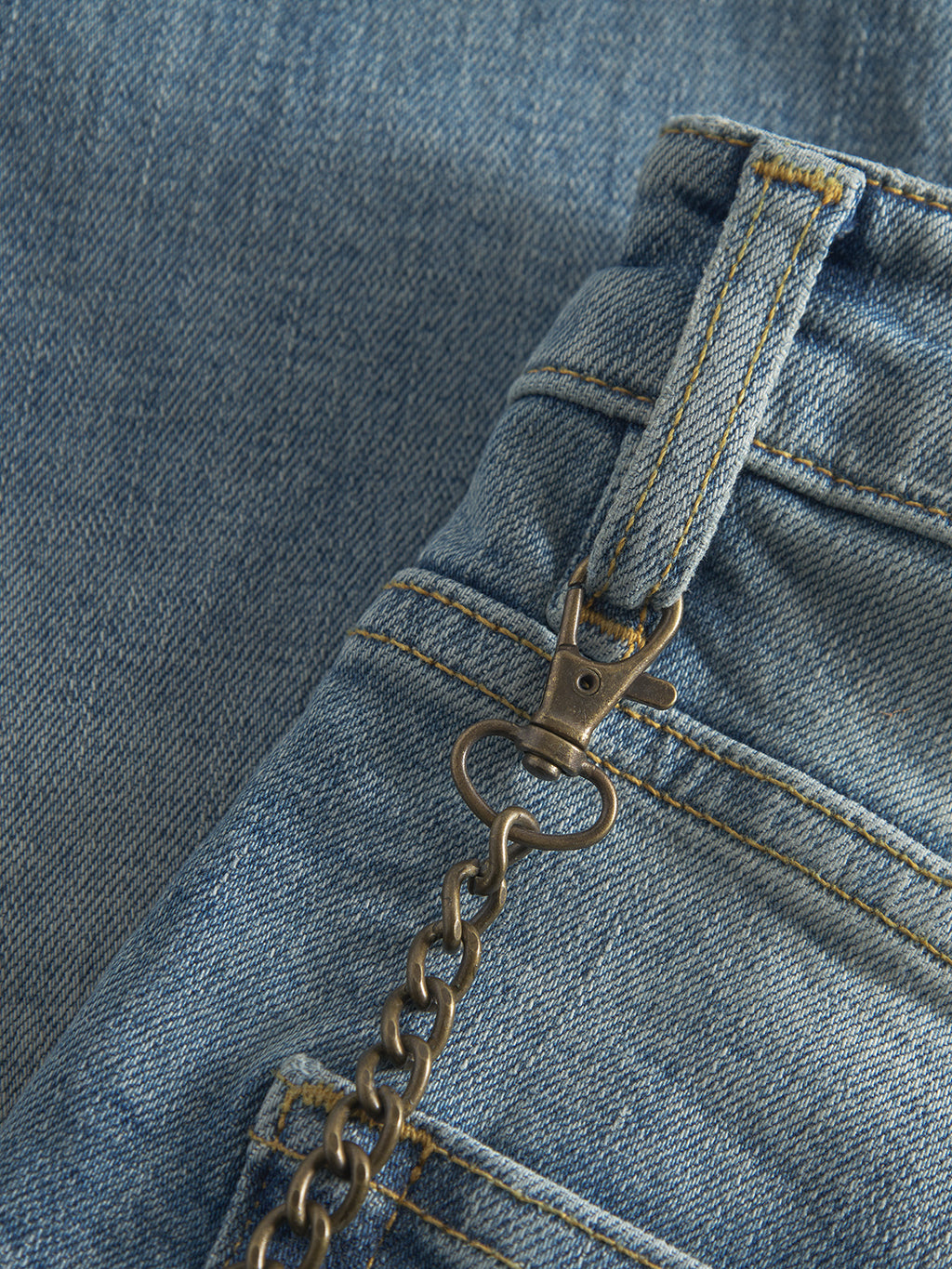 Close-up of Gabba GABalex Cros Cropped jeans in light blue denim with relaxed fit, a metal keychain clipped to the belt loop, and standout yellow stitching on cross-hatch fabric.