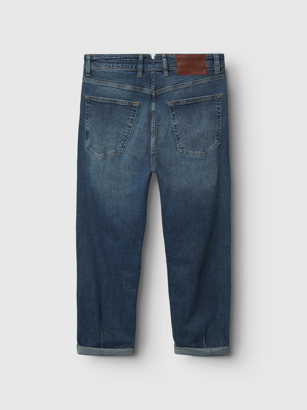 Rear view of Gabba GABalex Cros Cropped - Mid Blue Denim jeans in relaxed fit with rolled cuffs, two back pockets, belt loops, visible stitching, and brown leather patch. Made from recycled cotton cross-hatch fabric on a white background.