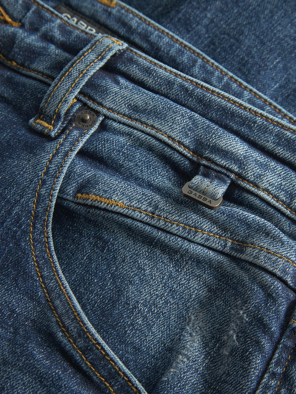 Close-up of Gabba GABalex Cros Cropped relaxed fit jeans in mid blue denim, featuring belt loops, a metal button, visible stitching, and textured cross-hatch fabric.