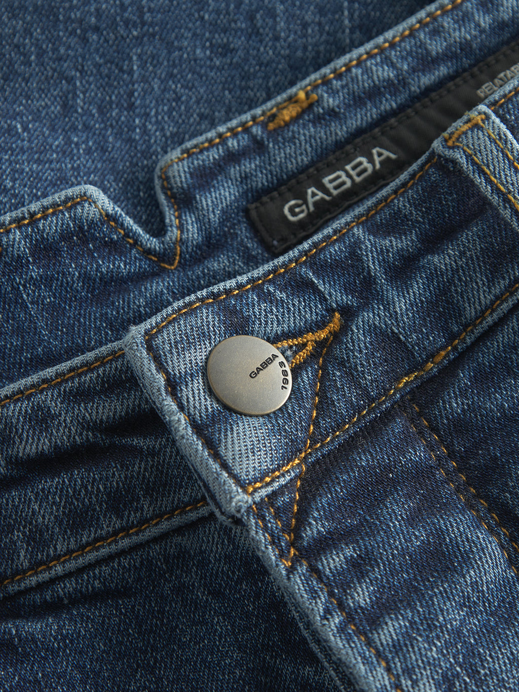 Close-up of GABalex Cros Cropped - Mid Blue Denim jeans by Gabba, made from recycled cotton with yellow stitching, a metal 