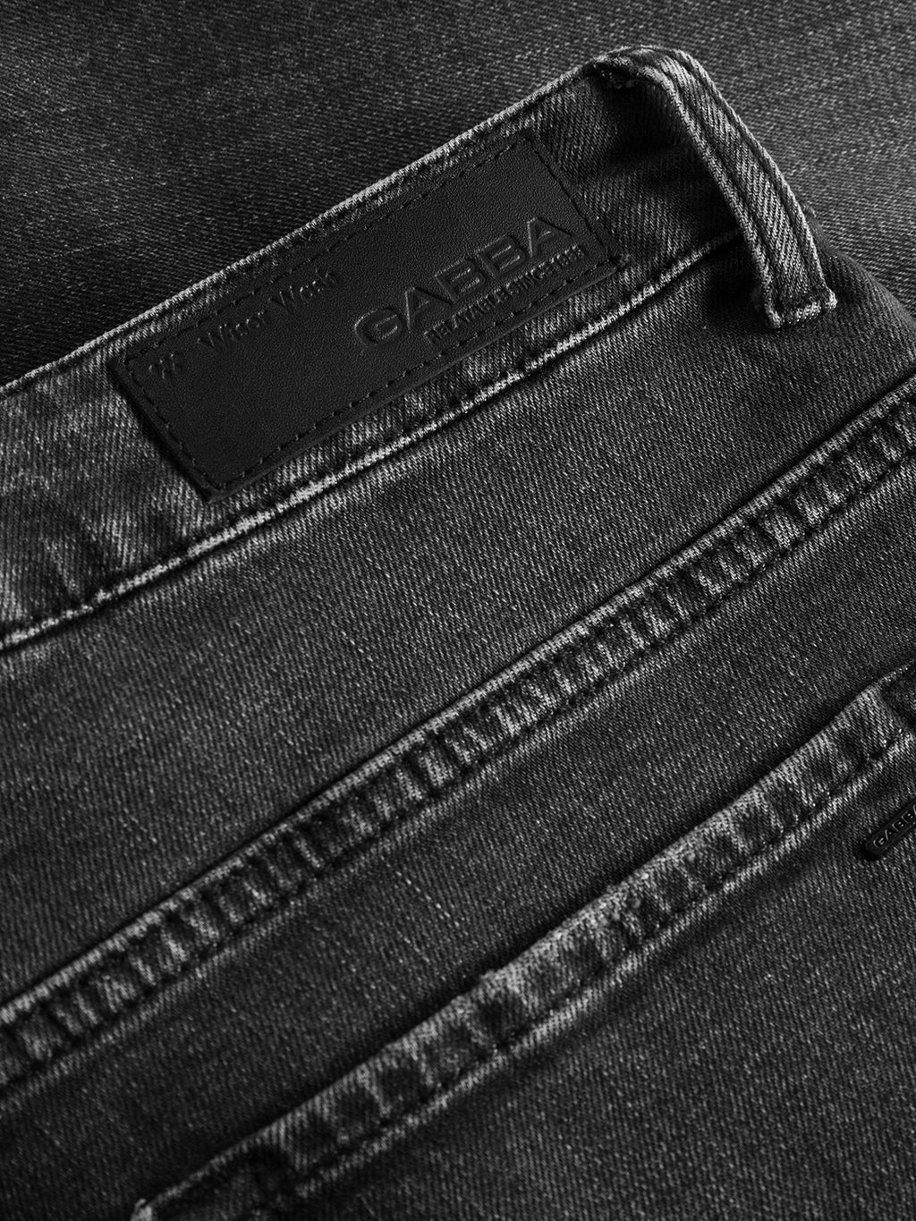Close-up of the back pocket and waistband of Gabba GABmarc F1011 - Black Denim jeans, featuring a leather Gabba patch and showcasing the detailed stitching and fabric texture.