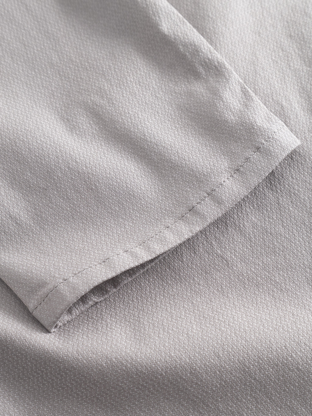 Close-up of the Gabba GABpaul K3280 Dale Chino in Grey Paloma, showing light gray fabric with a small textured pattern and neat hem stitching, characteristic of slim chinos near the leg opening or French pockets.