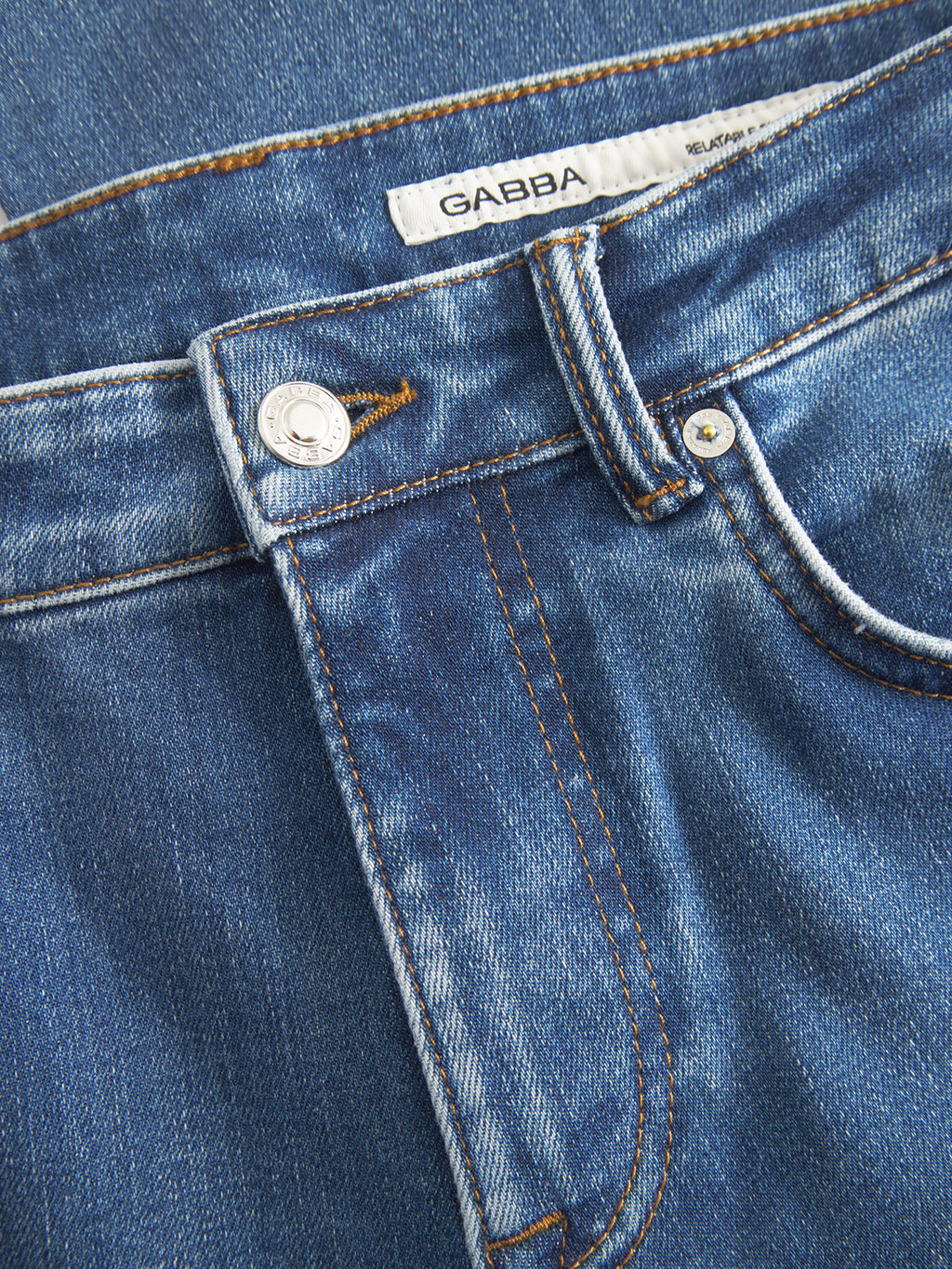 Close-up of dark blue denim GABjones2 Nham RS2113 Jeans by Gabba, featuring a pocket, belt loop, metal button, and a white label with the Gabba brand name sewn inside the waistband. Made from performance stretch denim in a dark blue wash, these slim straight fit jeans offer comfort and classic style.