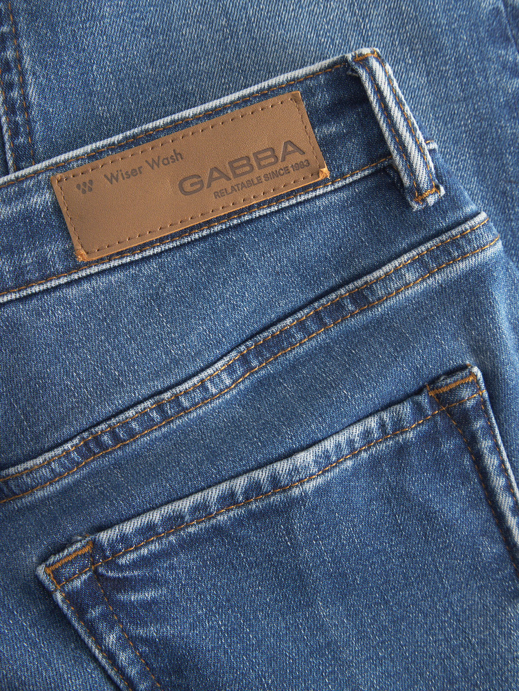 Close-up of the Gabba GABjones2 Nham RS2113 Jeans in dark blue denim, featuring a slim straight fit, visible stitching, and a brown leather patch label on the waistband that reads “Wiser Wash GABBA RELATABLE SINCE 1983.” Crafted from performance stretch denim for enhanced comfort and flexibility.