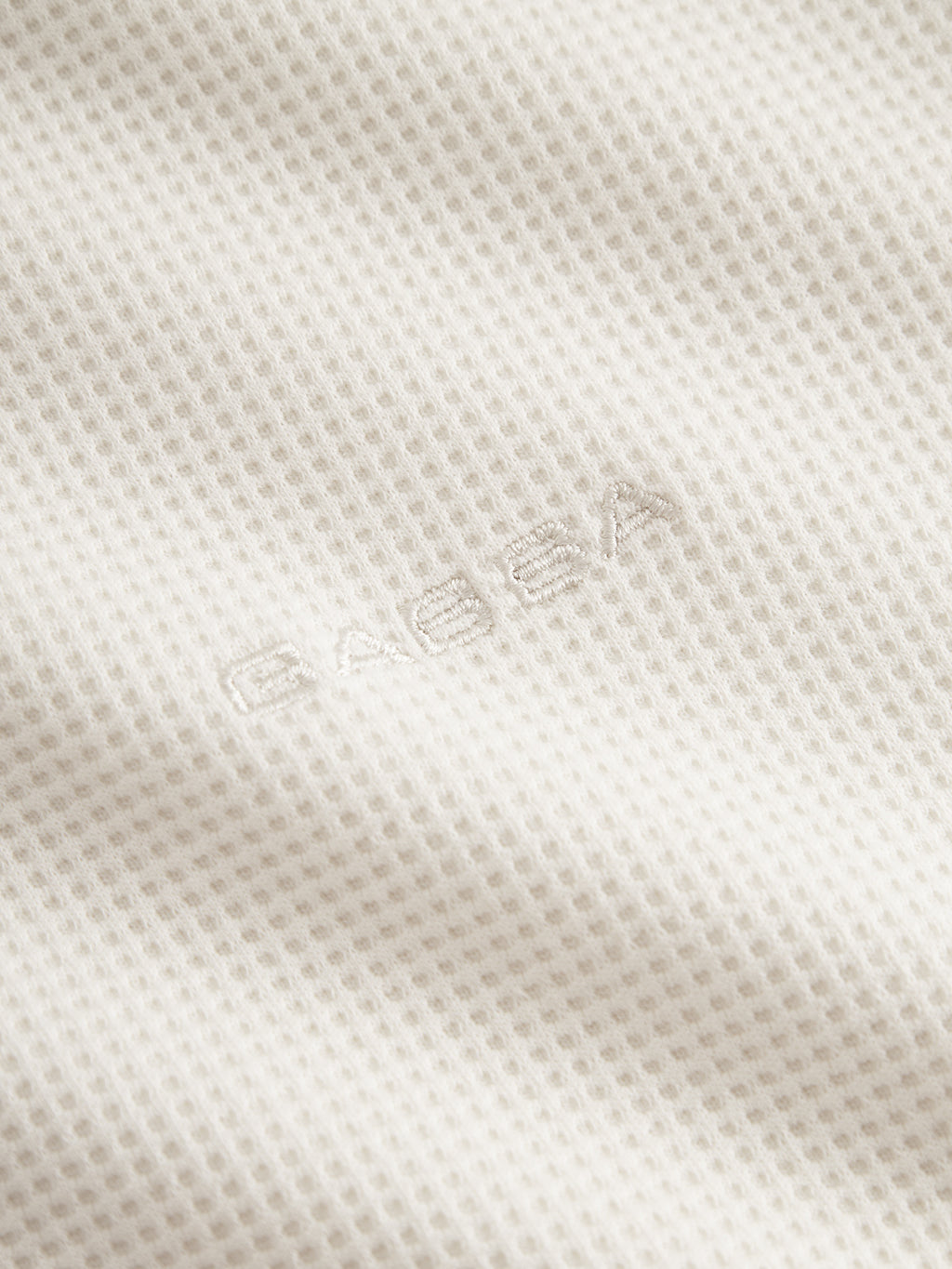 Close-up of the Gabba GABlio Waff - Bone White, featuring midweight waffle fabric with a grid-like texture and the Gabba logo subtly embroidered in white thread at the center.