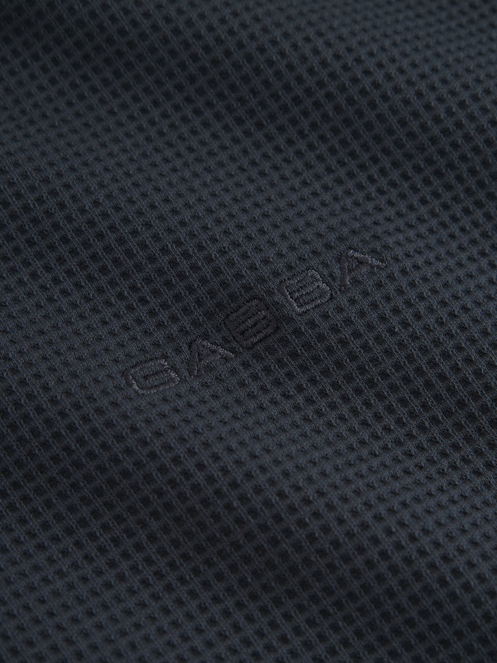 Close-up of the GABlio Waff - Navy by Gabba, showing its dark, textured midweight waffle fabric with a grid-like pattern and a subtle Gabba embroidery logo at the center.