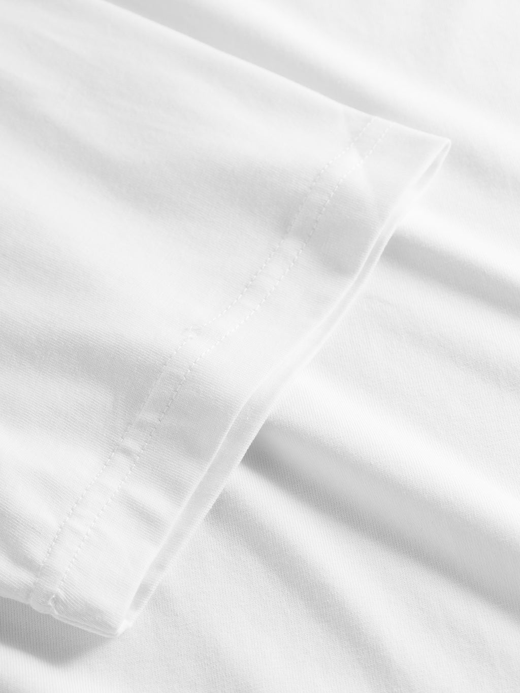 Close-up of the sleeve and side of the Gabba GABdune Logo GOTS SS T-Shirt in white, highlighting the stitching detail and smooth organic cotton fabric.