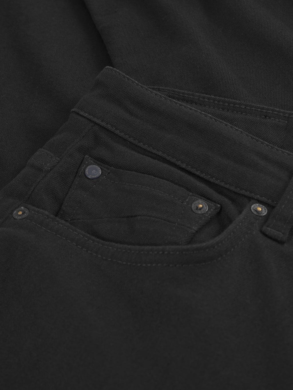 Close-up of the front pocket area of Gabba GABmarc Sword - Black Denim slim fit jeans, featuring clean stitching, a coin pocket, and metal rivets on intense black fabric.