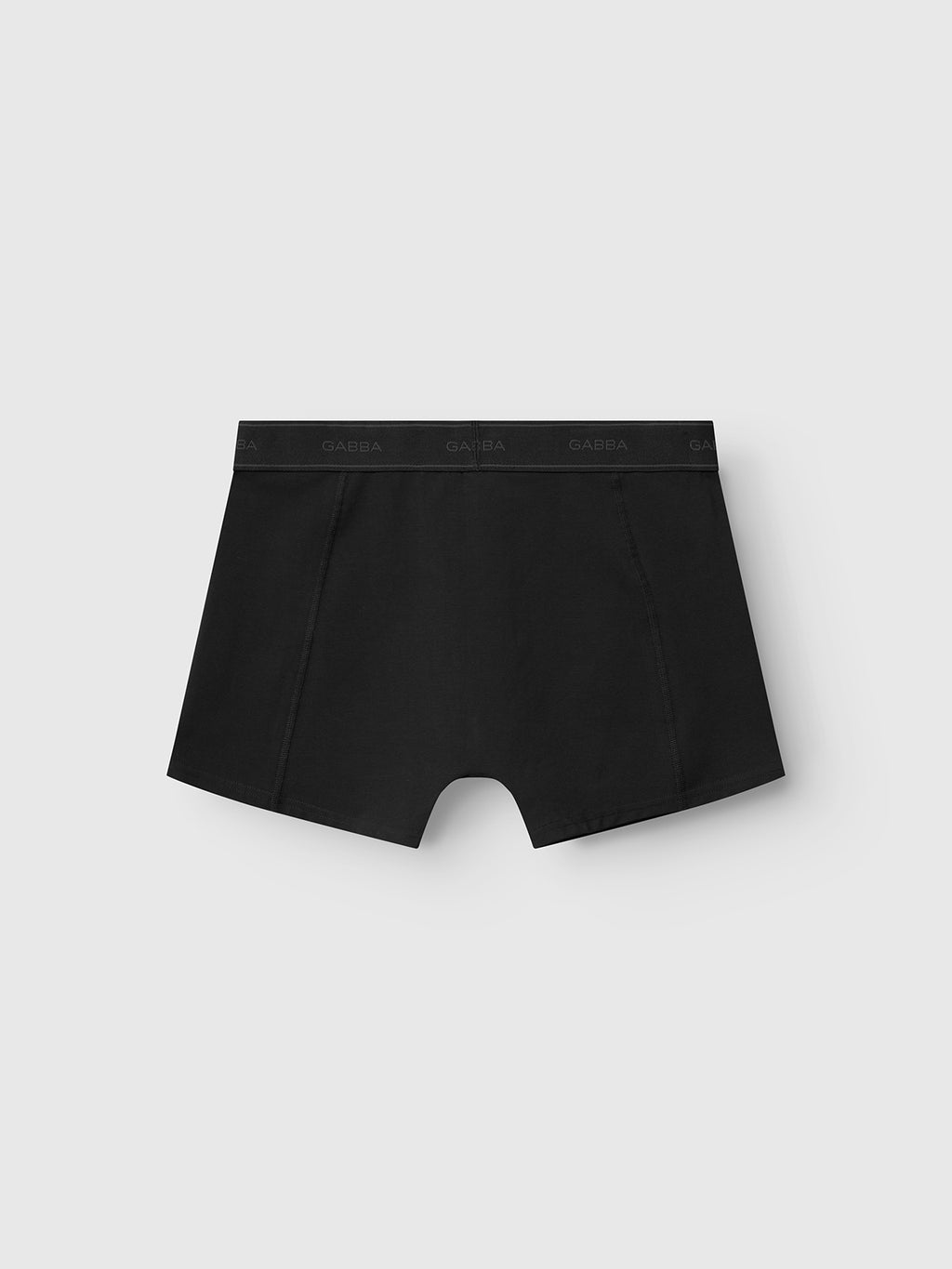 A pair of Gabba Trunk New - Black trunks, featuring a subtle Gabba logo on the elastic waistband and crafted from a soft cotton blend, displayed against a light gray background.