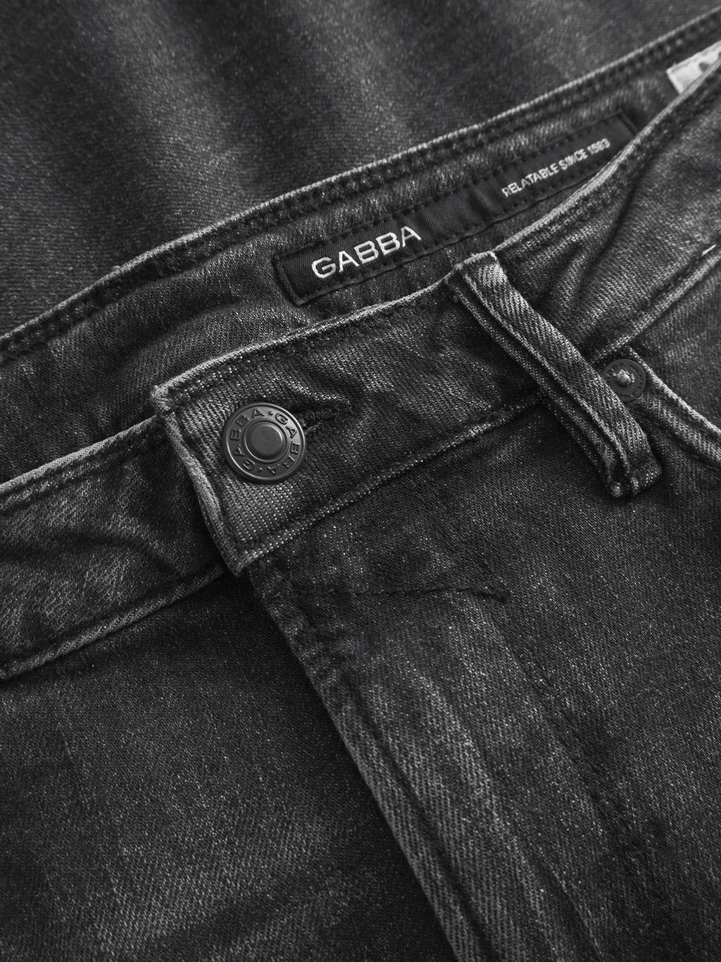 Close-up of the waistband and button on Gabba’s GABmax F1011 black denim slim fit jeans, showing the visible label plus detailed stitching and fabric texture.