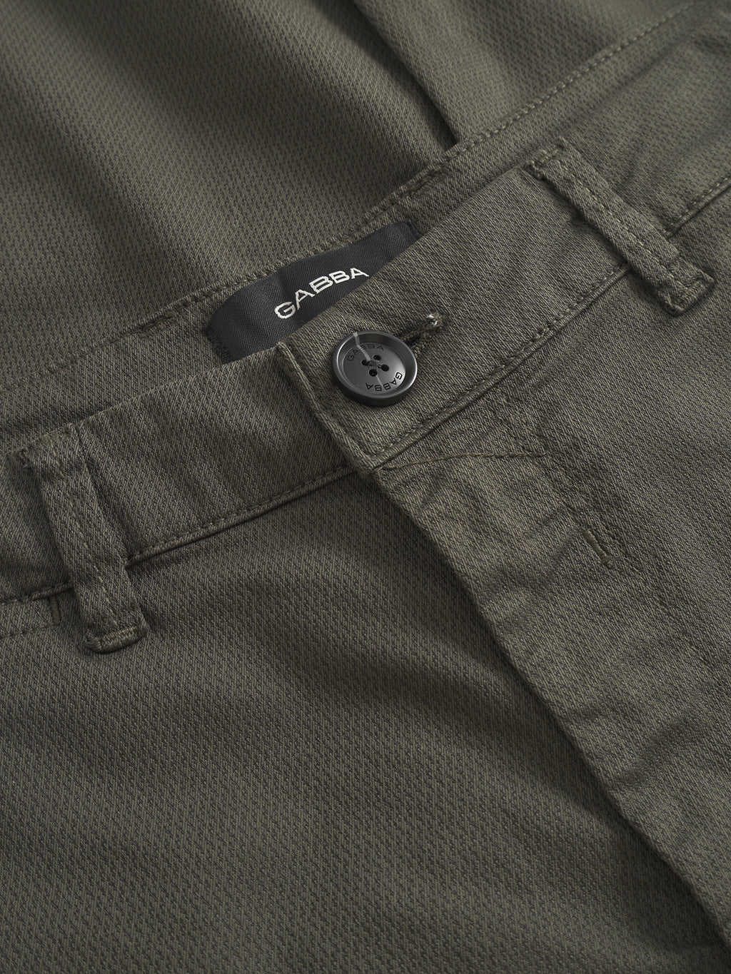 Close-up of Paul K3280 Cargo Dale - Army cargo pants by Gabba, featuring olive green textured fabric, slim fit, visible belt loops, branded button, and a GABBA label above the waistband.