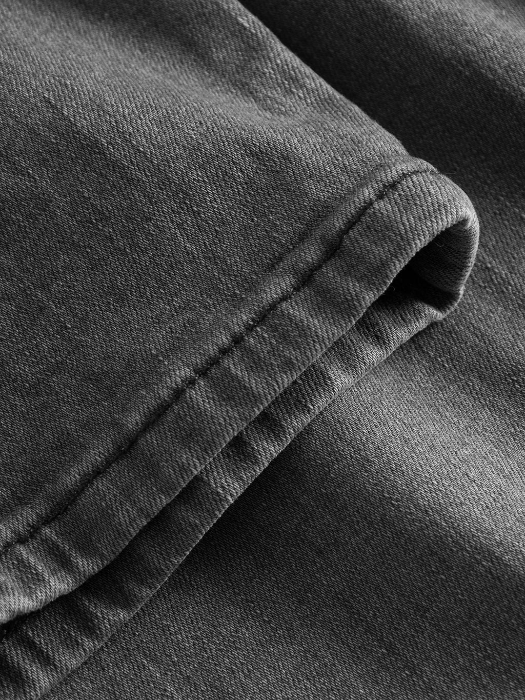 Close-up of a folded section of GABBA's GABrey K3454 - Denim wash, highlighting its detailed stitching and rich dark gray texture—ideal for versatile jeans combining style and comfort.