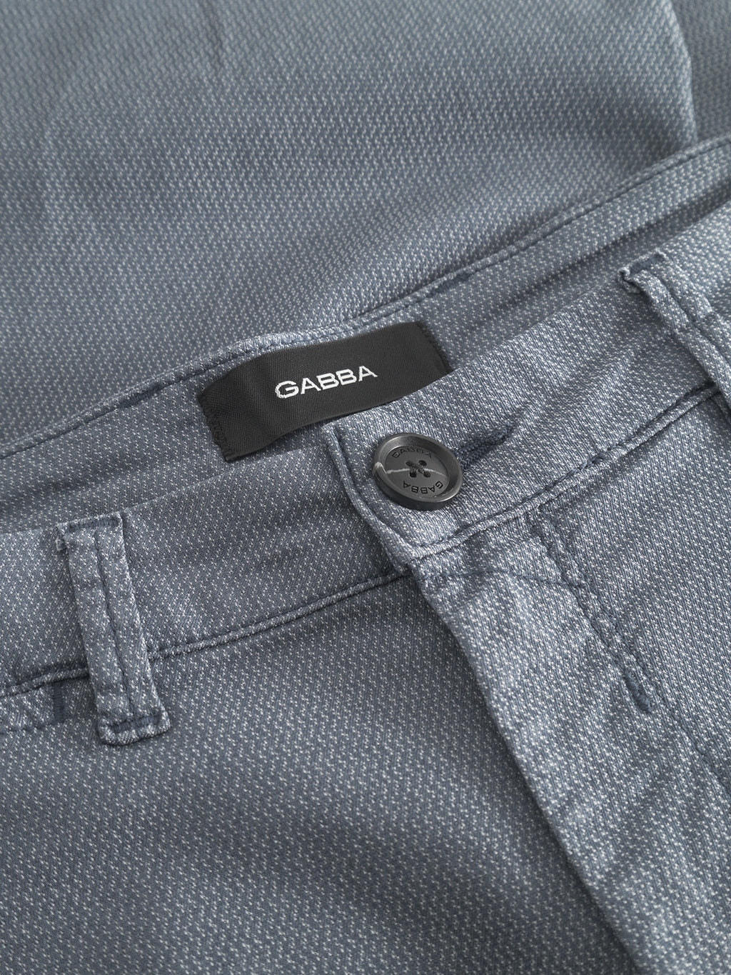 Close-up of the waistband and button of the GABpaul K3280 Dale Chino in blue. A black label above the waistband shows the Gabba brand in white, emphasizing its classic style.