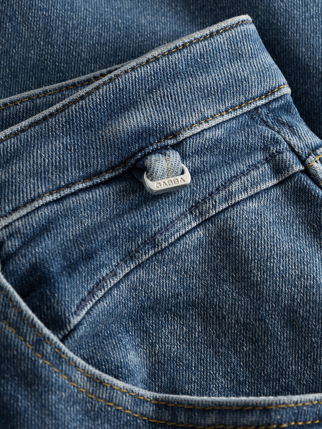 Close-up of GABBA Alex K3948 Jeans - Denim wash, showing the front pocket, metallic GABBA-engraved button, detailed stitching, and textured fabric that emphasize its fashion-forward fit and worker cut waistband.