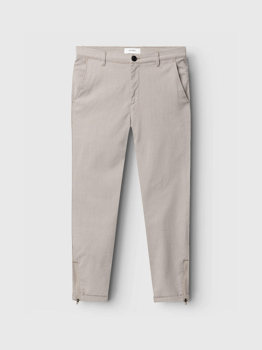 Pisa Domo Pants - Coriander by Gabba: Slim-fit light gray trousers featuring front pockets, a button and zip closure, and ankle zipper details, shown flat against a clean white background—a versatile choice ideal for styling on any occasion.