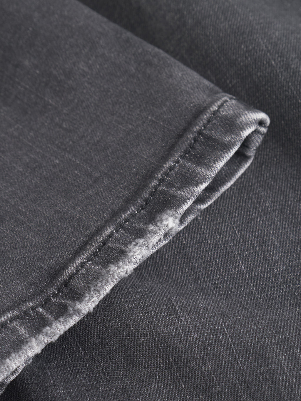 Close-up of the hem of Gabba GABmarc F1011 Black Denim jeans, showcasing the textured fabric and precise stitching detail along the neatly folded edge.
