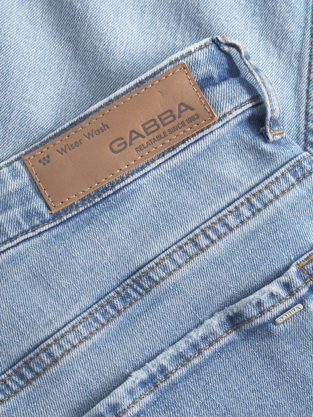 A close-up of Gabba GABmarc F1012 light blue denim straight fit jeans shows a brown leather patch with 