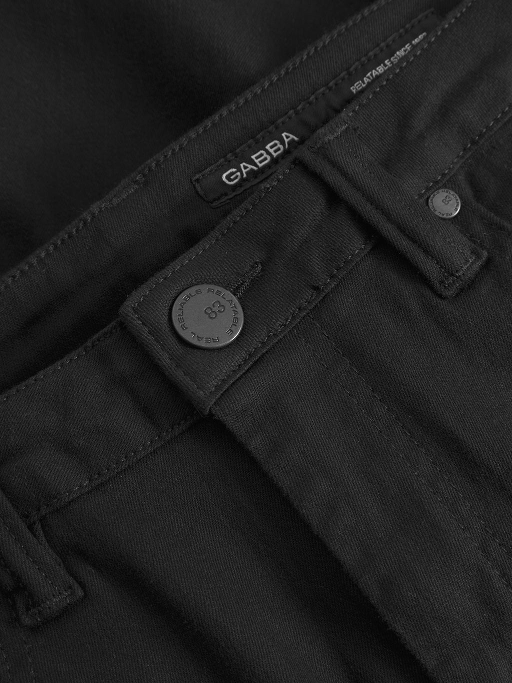 Close-up of the waistband and button on Gabba’s GABjones Hold Black Denim showcases detailed stitching, super-stretch fabric, rich texture, and a visible Gabba label.