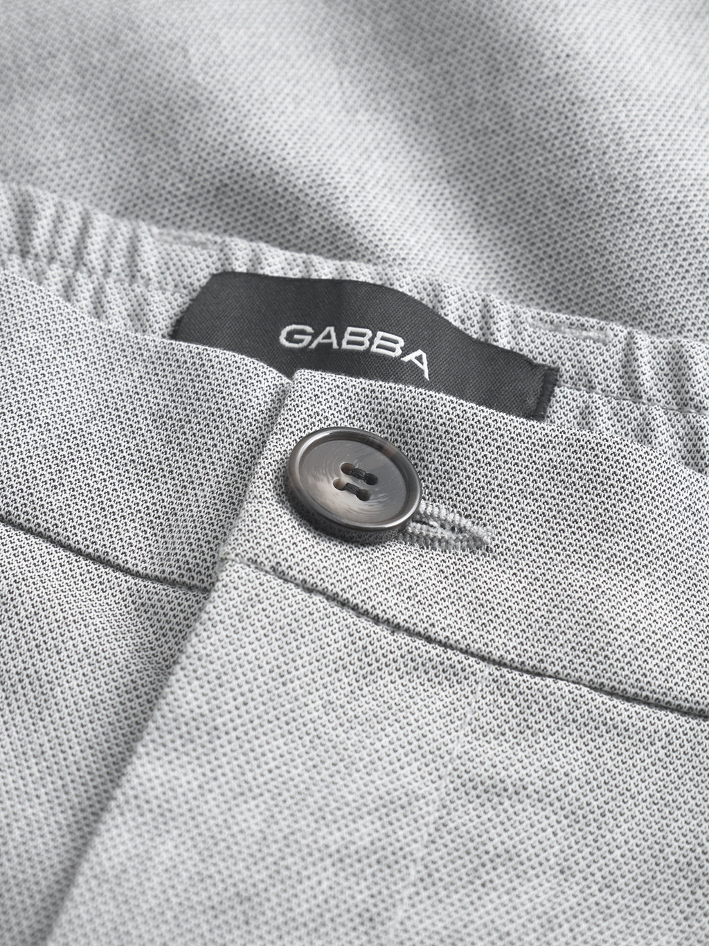 Close-up of Gabba Napoli 19 Carre - Lt. Grey pants, featuring a black brand label and dark grey button, showcasing classic style and a comfortable fit.