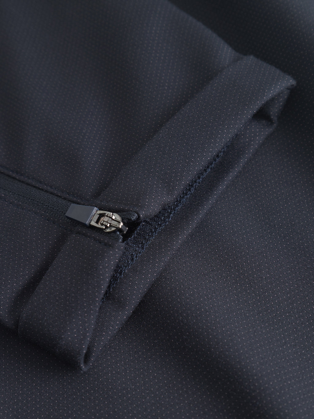 Close-up of a navy Pisa Small Dot sleeve by GABBA, showcasing a subtle dotted pattern and partially opened zipper—crafted from high-stretch cotton-blend fabric inspired by metro style.