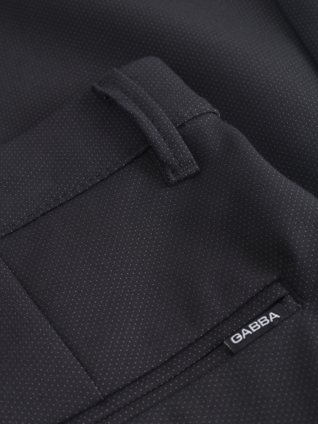 Close-up of a black textured fabric pocket on GABBA Pisa Small Dot - Black pants, with a belt loop and a small black GABBA label. Made from high-stretch cotton blend for comfort and modern metro style.