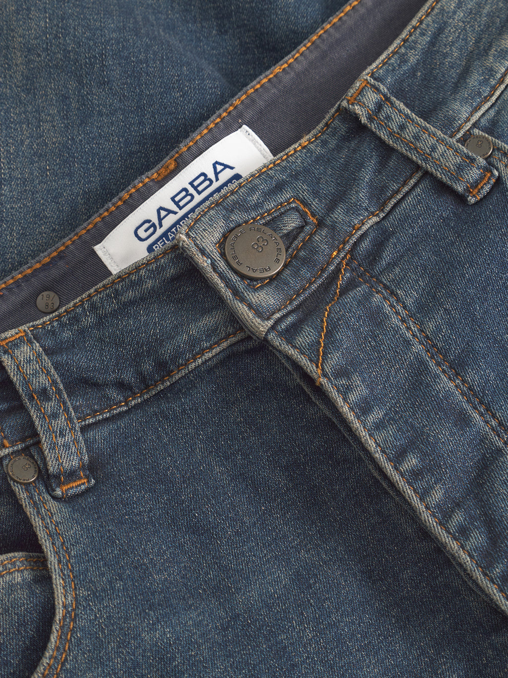 Close-up of GABBA GABrey K3606 Mid Blue Jeans in mid blue denim, featuring a metal button, orange stitching, and a visible white GABBA label above the waistband.