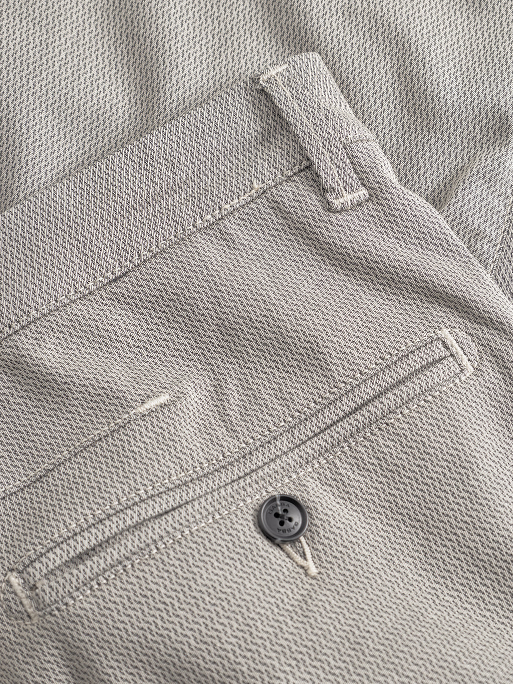 Close-up of Gabba's GABpaul K3280 Dale Chino in Birch: light gray textured fabric with slim fit, waistband and belt loops, French pockets, a buttoned back pocket, and neat stitching for a refined finish.