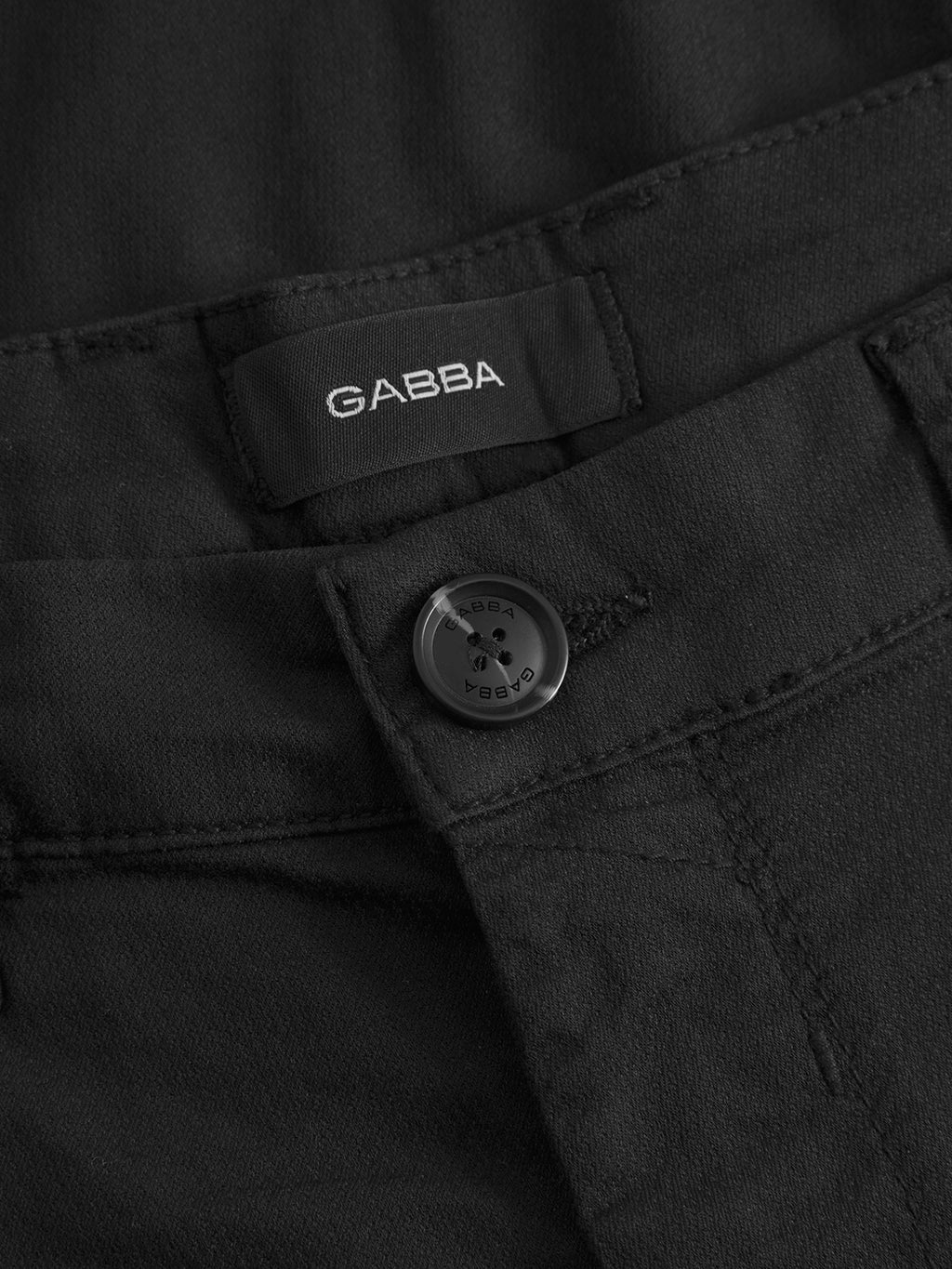 Close-up of the waistband on GABBA's GABpaul K3280 Dale Chino in black, featuring a black button, French pockets, and an inner fabric label with the GABBA brand name stitched inside.
