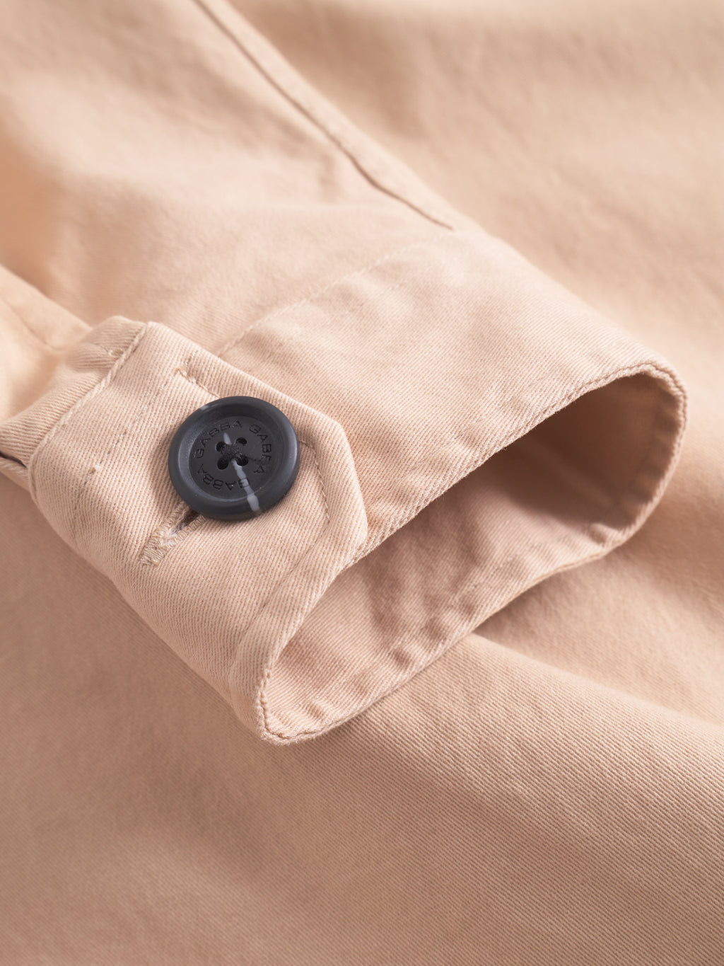 Close-up of the GABBA GABtopper LS Shirt - Humus sleeve, featuring a black cuff button and detailed stitching that highlights the shirt’s textured beige fabric.