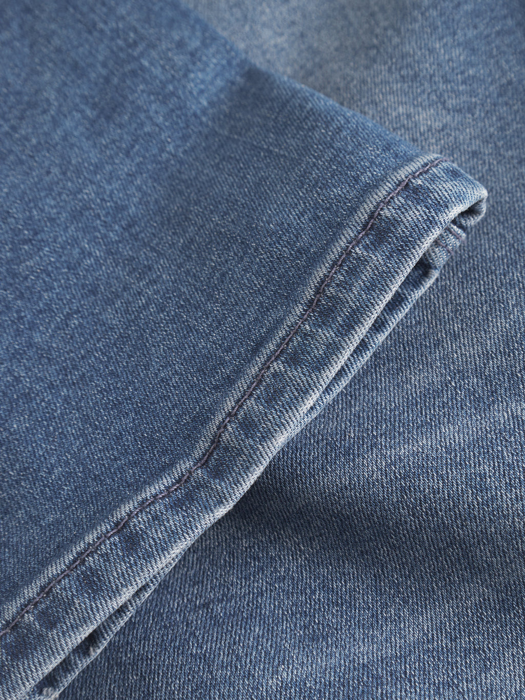 A close-up of the cuff and leg of GABBA GABrey K3866 TENCEL™ Jeans in denim wash highlights the blue denim fabric’s texture and stitching for a relaxed style.