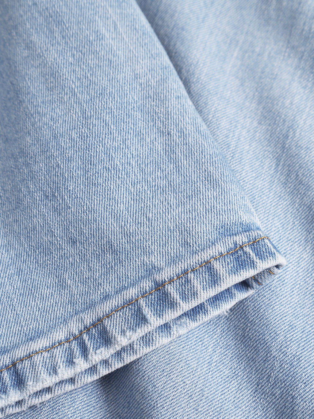 Close-up of GABmarc F1012 - Lt. Blue Denim by Gabba, highlighting the hem's visible stitching and textured woven fabric in a classic fit style.