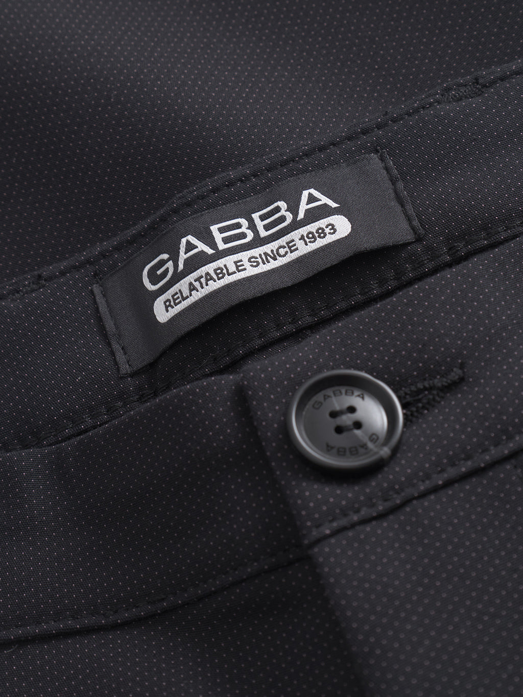 Close-up of GABBA Pisa Small Dot - Black pants made from high-stretch cotton blend, featuring small white dots, a GABBA label reading 