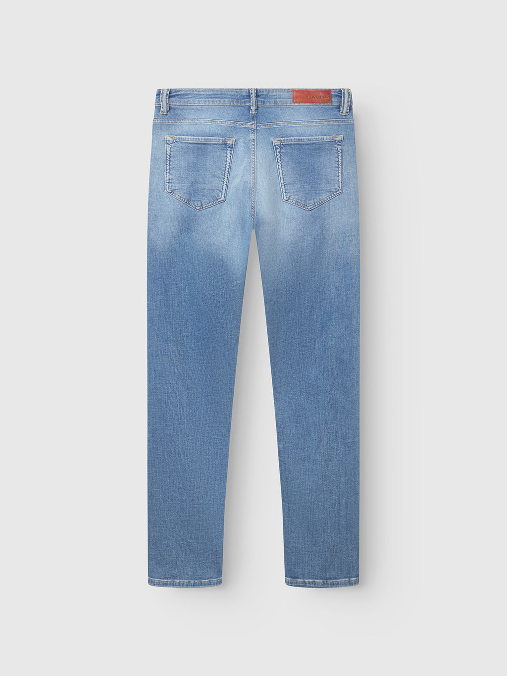 Back view of GABBA GABjones K2615 Lt. slim, light blue denim jeans with straight legs, two back pockets, and a brown leather patch on the waistband. Made from super-stretch fabric, shown flat on a white background.